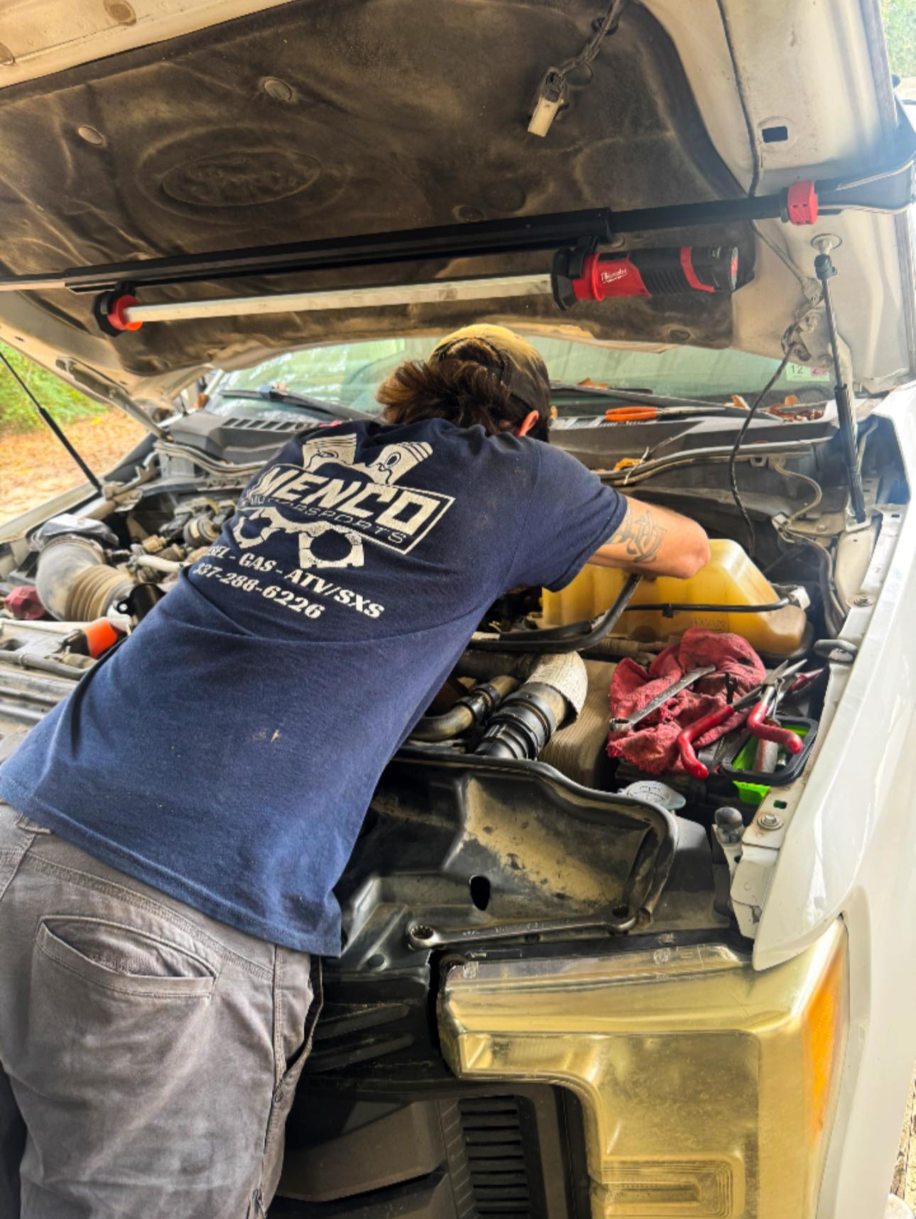 Menco Motorsports mechanic working on a diesel truck engine